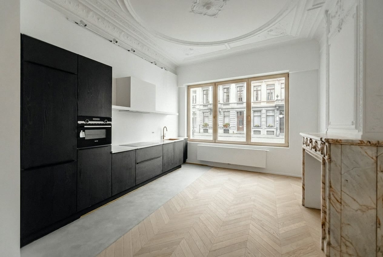 Zwarte keuken in een herenhuis met ornamentplafond