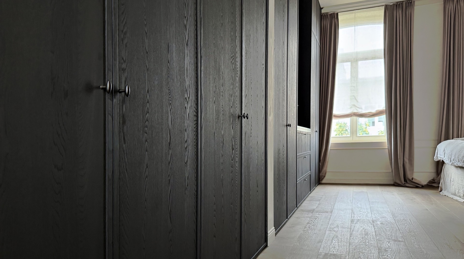 Dressing in zwart geborsteld eikenfineer met opliggend kader en bronzen knoppen